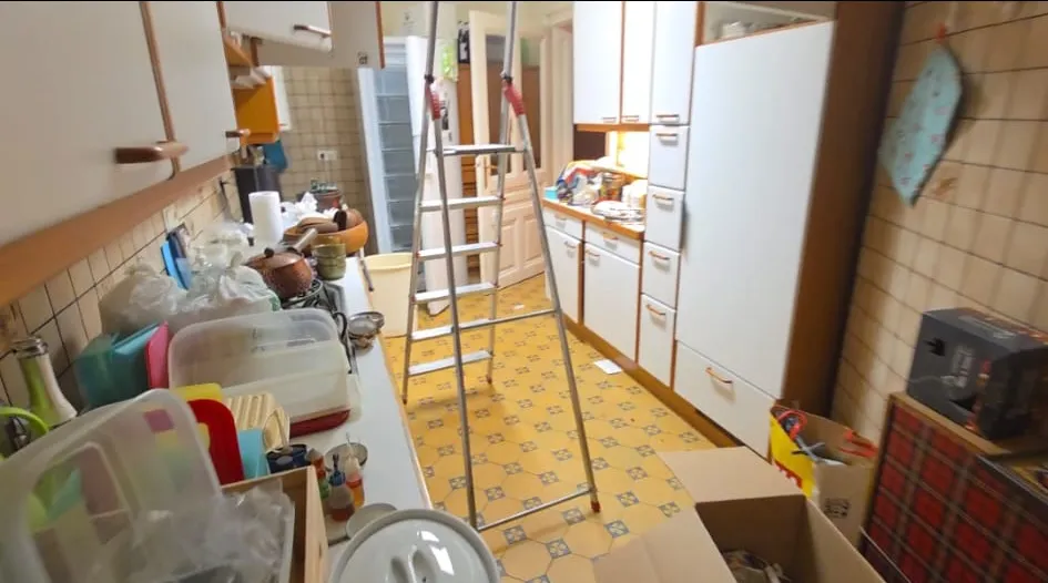 Küche im 9. Bezirk vor der Entrümpelung – Leiter blockiert den Durchgang