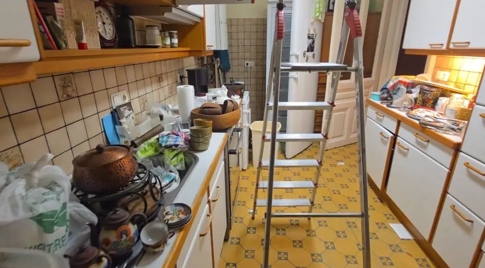 Küche im 9. Bezirk vor der Entrümpelung – starker Hausrat entlang der linken Küchenzeile