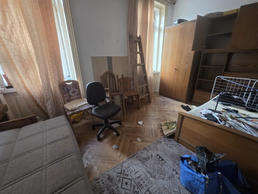 Verlassenschaft Entrümpelung Wien 1010 Innere Stadt: vollgestelltes Zimmer vor der Räumung mit Stühlen, Leiter und Kleiderschrank auf Parkettboden